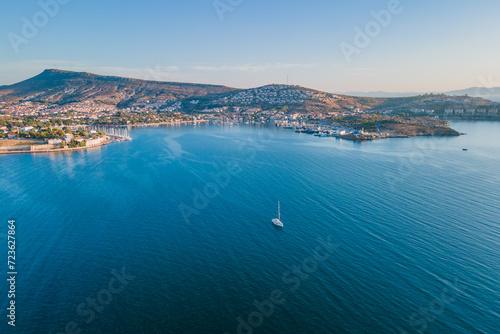 Aerial view of a yacht sailing in the sea from Foca resort town coast side on a sunny day