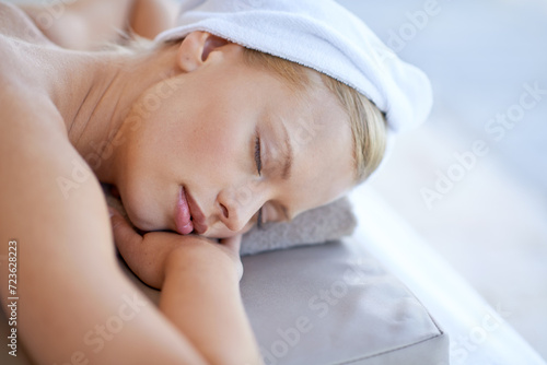 Woman, relax and sleep on table in spa for skincare, beauty and luxury treatment for wellness with peace. Person, rest and lying on bed in hotel or salon for massage or dermatology care for body