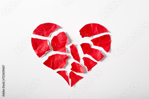 Pieces of crumpled and torn red heart shape paper isolated on white background paper. Broken heart concept.
