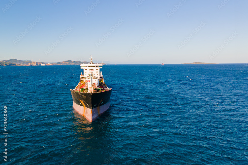 Front view on petrochemical oil product cargo ship carrier at anchorage in sea. Aerial view