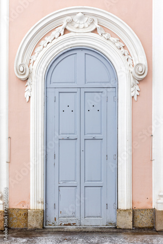 Arched closed gray wooden door in pink wall, background texture © evannovostro