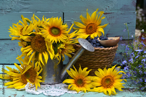 Beautiful still life with suflowers and blue berry in the garden. Romantic greeting card for birthday, Valentines, Mothers Day concept. Summer countryside background with vintage objects photo