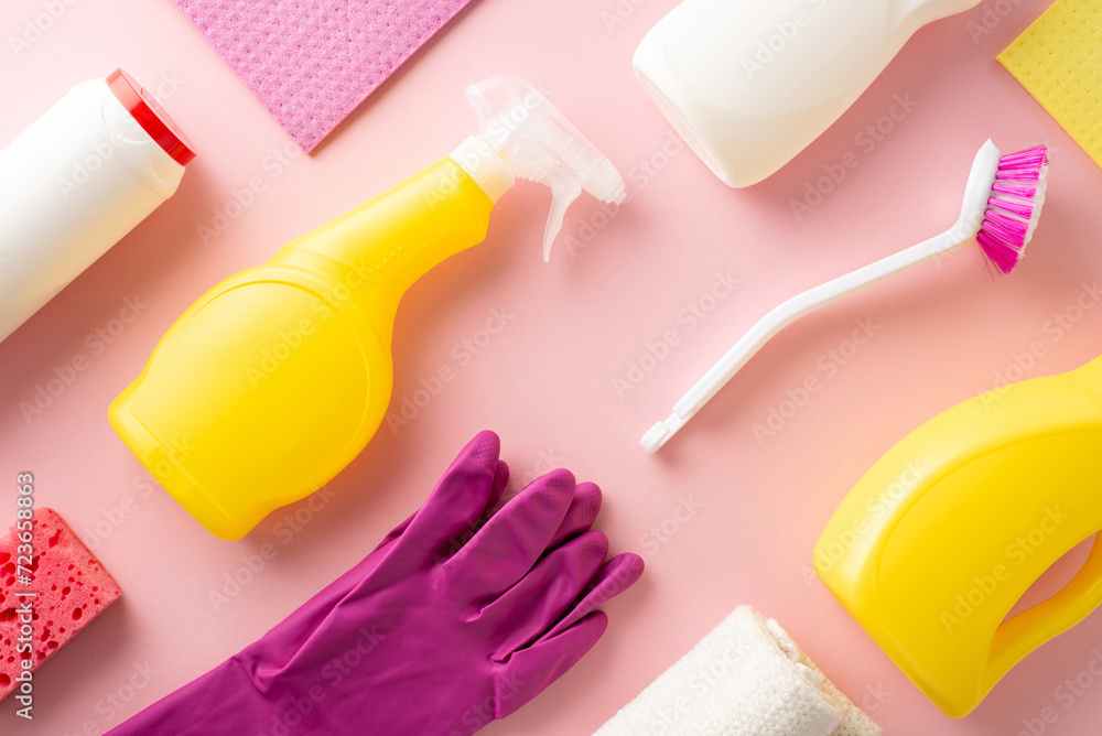 A neat pattern display of ordered housecleaning tools including gels, sprays, gloves, a dusting cloth, and sponge, all on a soft pink background with a clear area for text or labeling - obrazy, fototapety, plakaty 