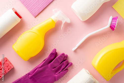 A neat pattern display of ordered housecleaning tools including gels, sprays, gloves, a dusting cloth, and sponge, all on a soft pink background with a clear area for text or labeling photo