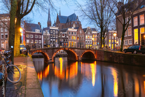 Amsterdam canal Leidsegracht with typical dutch houses and bridge at night, Holland, Netherlands photo