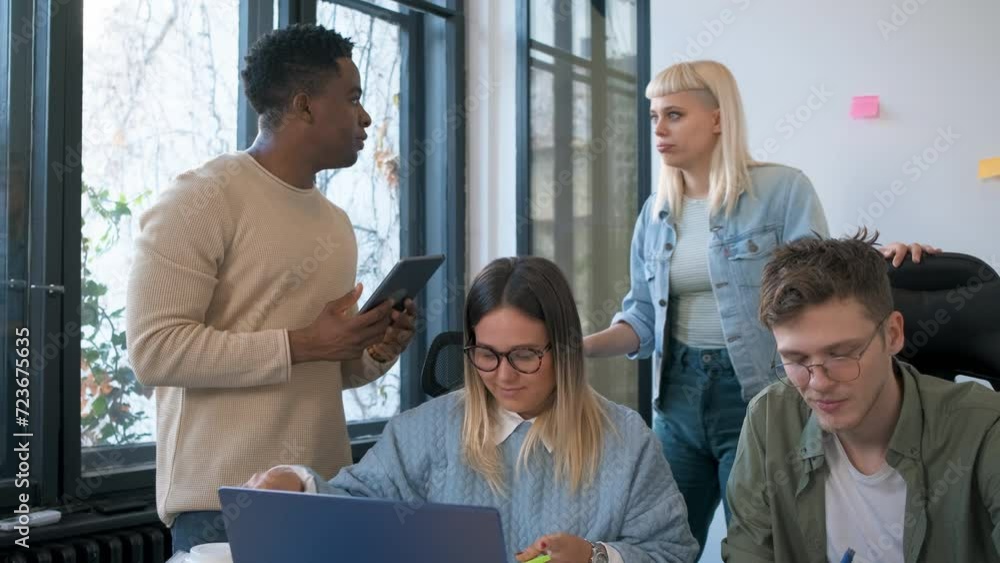 Diverse group of young business people working on new project together in office. Diverse group of young business people working on new project together in office.