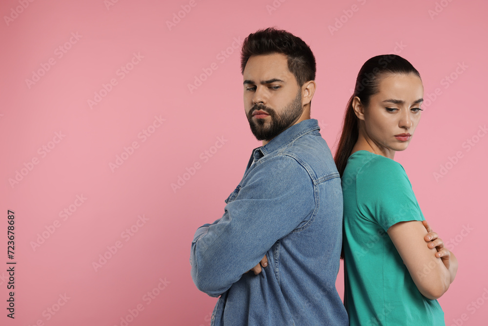 Resentful couple with crossed arms on pink background, space for text Resentful couple with crossed arms on pink background, space for text
