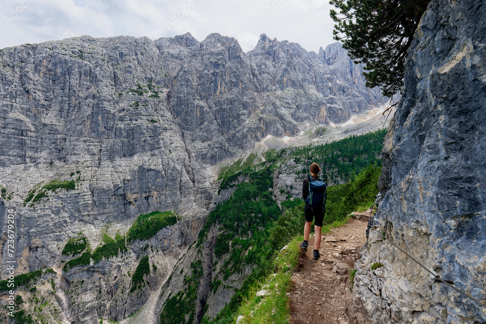 A female person admiring the view of mountains in the Dolomites, Italy. Famous places for hiking.