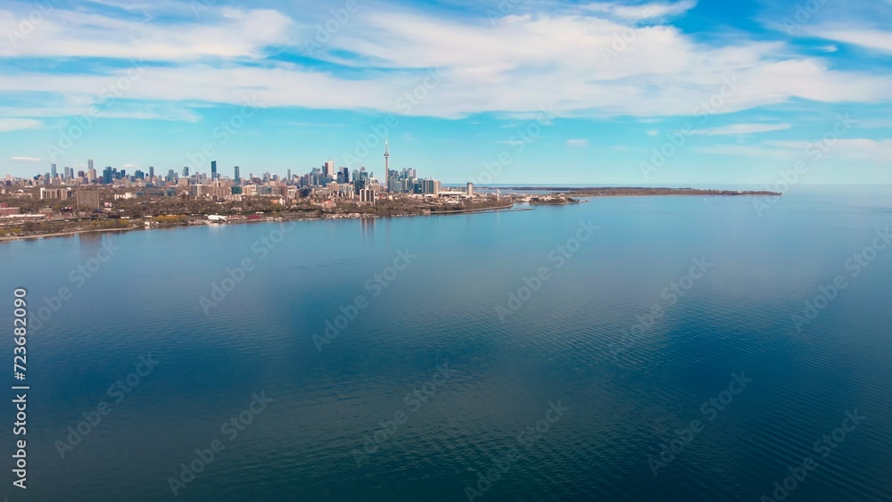 Canadian lake meets large city, clear day, highlighting ecology. Ecology prominent lake graces city, clear skies. Clear day, lake-city interface, ecology focus. balance nature development. Drone view.