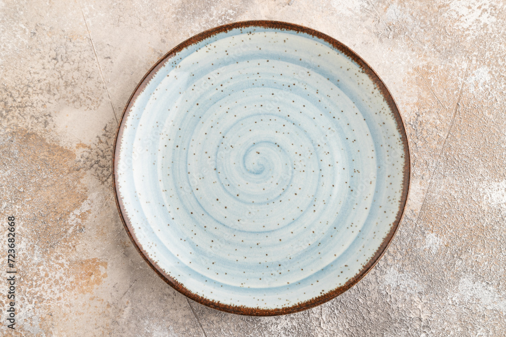 Empty blue ceramic plate on brown concrete background. Top view, copy space