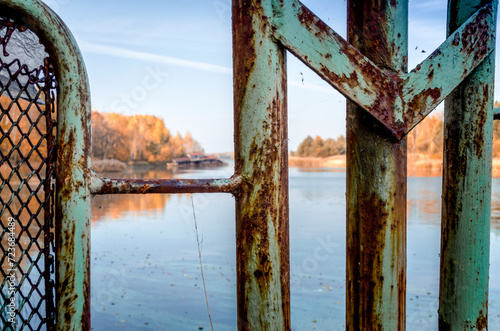 landscape river and iron fence with an old house in Chernobyl in autumn photo