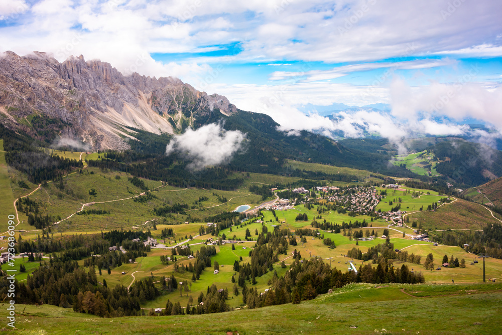 Obraz premium Dolomite alps with a mountain village and green meadows