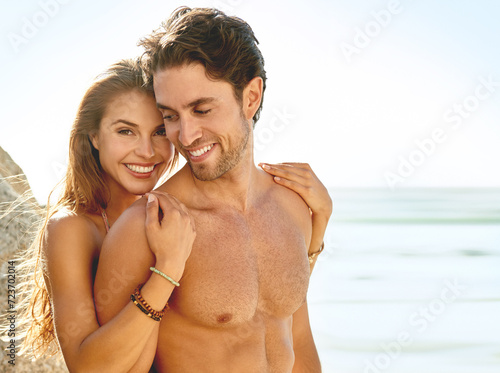Happy couple, portrait and hug on beach for love, care or support on holiday or outdoor weekend. Face of young man and woman smile for embrace, trust or summer sunshine by ocean coast on mockup space