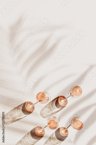 Rose wine glasses Minimal above view. Aesthetic still life photo, top view wineglass at sunlight, palm leaf sun shadow, Concept of taste, alcohol, wine degustation, wine list. Flat lay