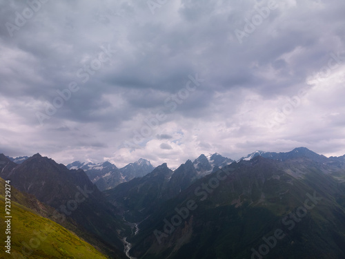 Aerial View of mountain tops, warm summer day, clouds in the sky, way to Ushba mountain and Koruldi lakes. Concept of vacation and travel to Georgia. Nature, Mestia, Svaneti mountains