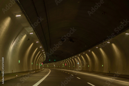 Underground city road tunnel, curve night illuminated freeway with car