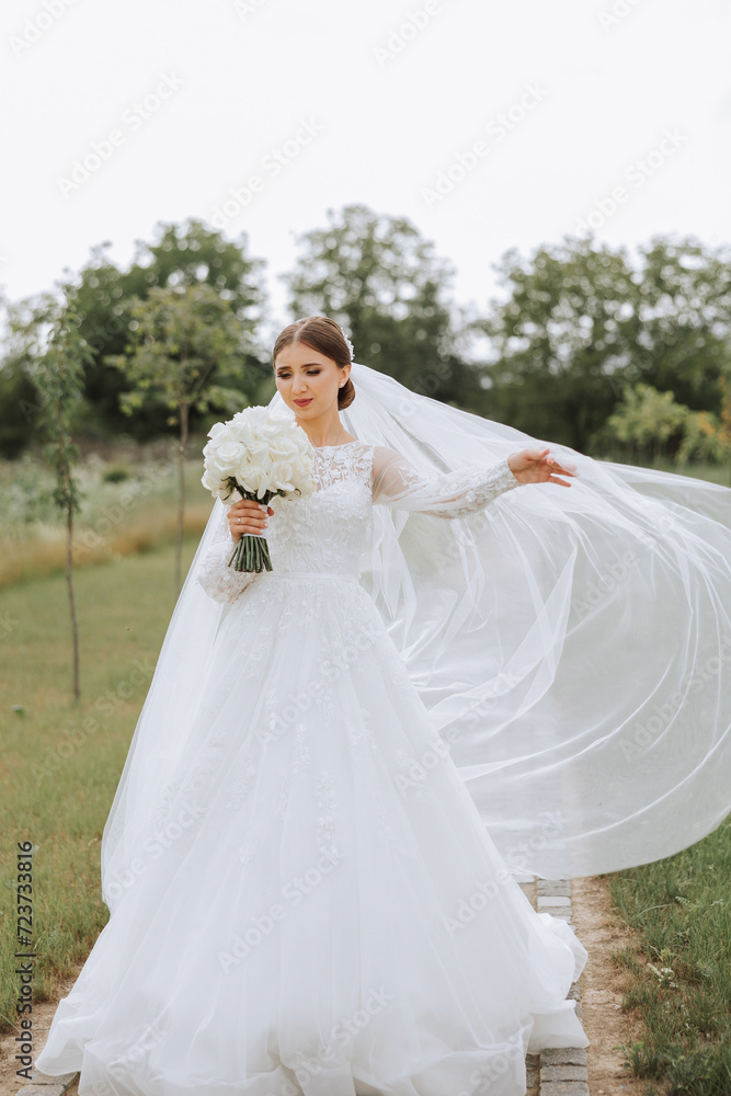 portrait of a beautiful young bride in a white dress with a long veil and a gorgeous hairstyle. Smiling bride. Wedding day. Gorgeous bride. Marriage. portrait of a beautiful young bride in a white dress with a long veil and a gorgeous hairstyle. Smiling bride. Wedding day. Gorgeous bride. Marriage.