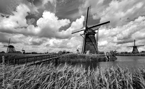19 windmills of “Kinderdijk“ is an iconic dutch tourist site, world heritage spot and national monument. Panoramic view of renovated water pumps in Alblasserwaard polder, Netherlands, black and white. photo