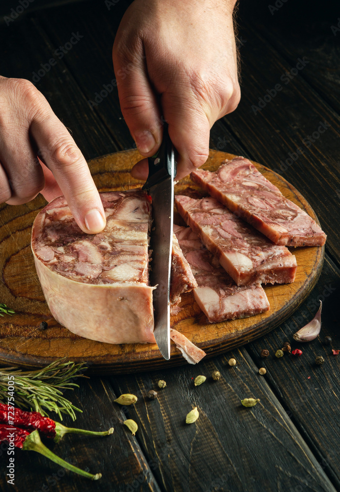 Prepare a quick and tasty snack. A man hands use a knife to cut brawn from meat on a cutting board