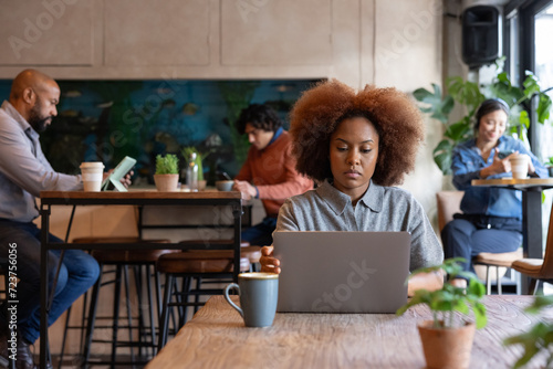 Young female freelancer working from a cafe photo