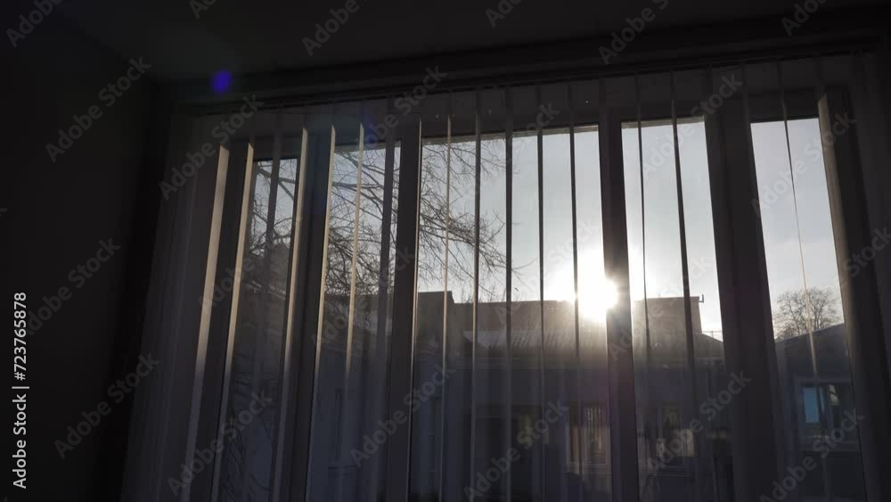 Opening window blinds through which the sun's rays appear. Opening window blinds through which the sun's rays appear.