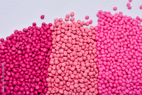 Fototapeta Naklejka Na Ścianę i Meble -  masterbatch granules in three kinds of pink on a white background, this polymer is a colorant for products in the plastics industry