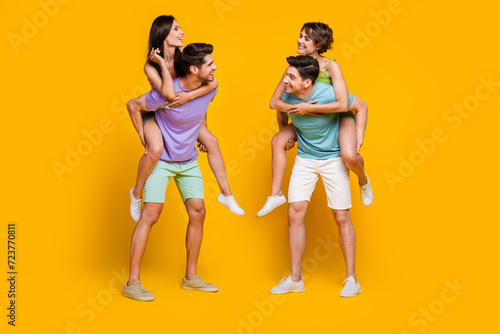 Full length photo of people fellows have talk guys piggyback ladies isolated bright color background