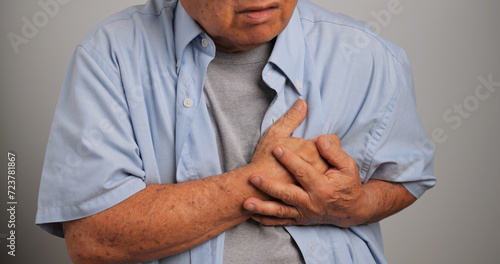 An elderly man is suffering from heart disease. Old Asian man having heart problems.