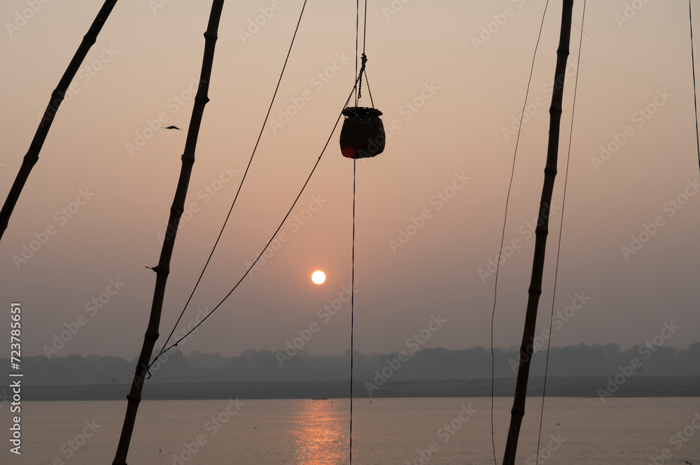 Varanasi , India - 10 December 2023 Early in the Morning Bamboos are tied on the banks of river Ganga to celebrate the Akash Deep festival at Panchganga Ghat Varanasi Uttar Pradesh....