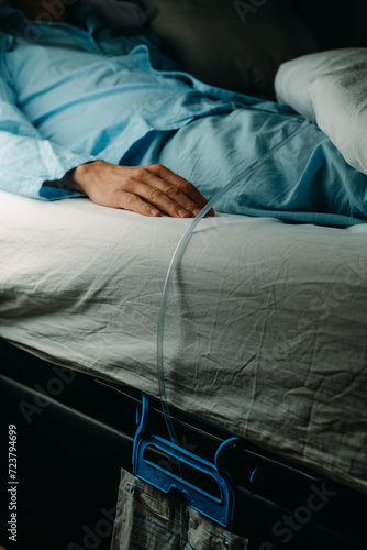 man wears a urine drainage bag lying in bed photo