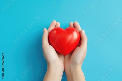 A person holding a red heart in their hands. Perfect for expressing love and affection.
