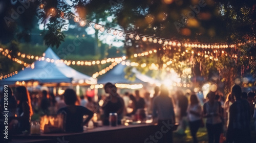 Blurred image of people at outdoor festival with bokeh lights
