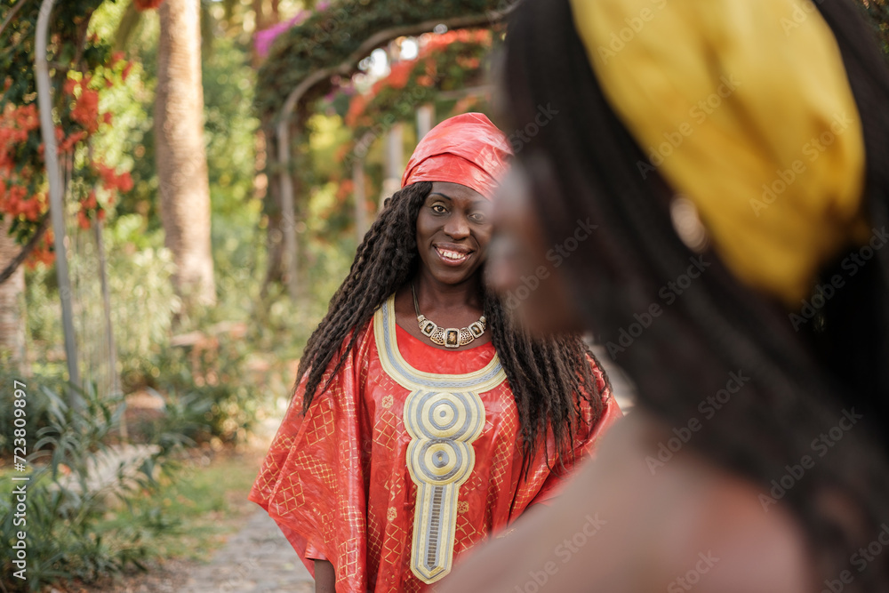 Woman in the foreground out of focus and behind in focus a woman with a typical African costume Woman in the foreground out of focus and behind in focus a woman with a typical African costume