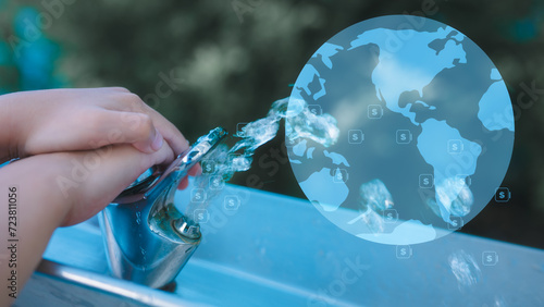 save water girl hand pressing on tap or water dispensor outdoor with virtual glob and blurred green garden background photo