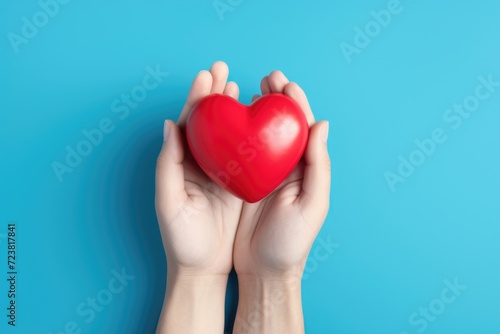 A person holding a red heart in their hands. Can be used for love  relationships  and Valentine s Day concepts