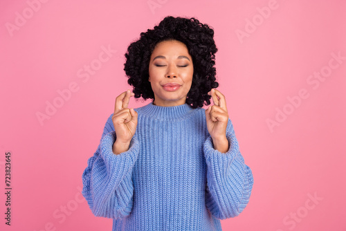 Photo of attractive young woman crossed fingers make wish dreaming dressed stylish blue knitwear clothes isolated on pink color background © deagreez