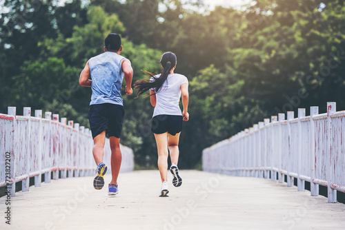 Couple running together on road across the bridge. Couple, fit runners fitness runners during outdoor workout