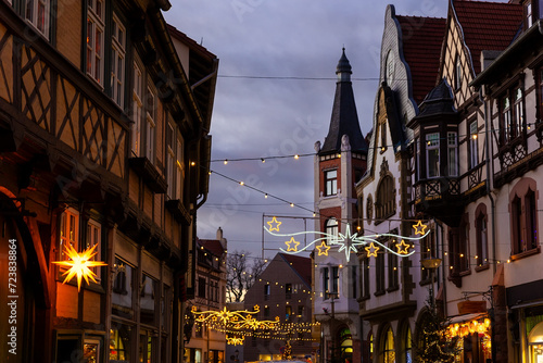 Charming Wernigerode town evening street view illuminated with Christmas lights garlands Herrnhutter stars on historical half-timbered houses facade. Twilight Festive city in Germany photo
