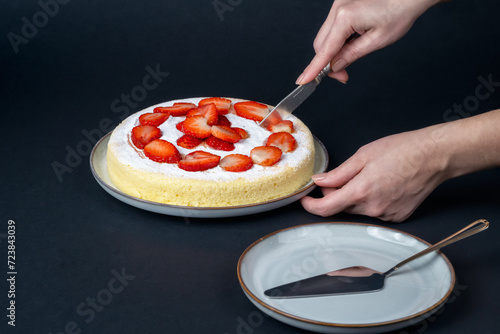 Still life with homemade japanese fluffy cheesecake arranged with fresh strawberries on a dark background