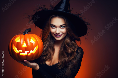 Smiling british woman in witch hat holding jack o lantern, dark red background