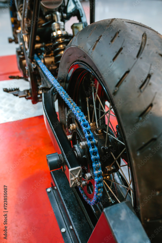 custom made wallpaper toronto digitalClose up of rear wheel and decorative blue chain on custom motorbike on factory. Back view of vintage scrambler motorcycle ready to review on mechanic garage.