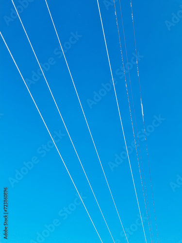 High-voltage power lines against a blue sky