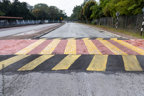 Photography Speed bump or road hump in yellow and black stripe to slow down vehicles and pro
