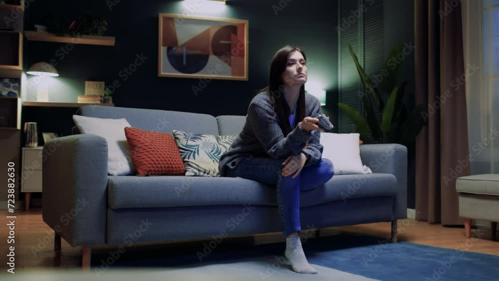 Young beautiful woman watching fun movie on television at home. Attractive casual girl feel happy and relax, sitting on sofa having fun watch comedy video on TV in house. Activity lifestyles concept. Young beautiful woman watching fun movie on television at home. Attractive casual girl feel happy and relax, sitting on sofa having fun watch comedy video on TV in house. Activity lifestyles concept.