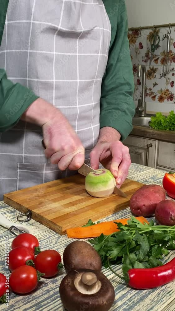 Culinary concept, preparation ingredients for homemade food. Vertical shot an unrecognizable man in an apron cooking a meal, cutting a turnip or radish on kitchen counter indoors. Vegetables on table Culinary concept, preparation ingredients for homemade food. Vertical shot an unrecognizable man in an apron cooking a meal, cutting a turnip or radish on kitchen counter indoors. Vegetables on table