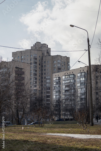 KYIV, UKRAINE - JANUARY 29, 2024: Old houses stand in Borshchahivka district. the sun is shining outside, the sky is blue. Borshchahivka is a calm and cozy area. People and cats are walking. photo