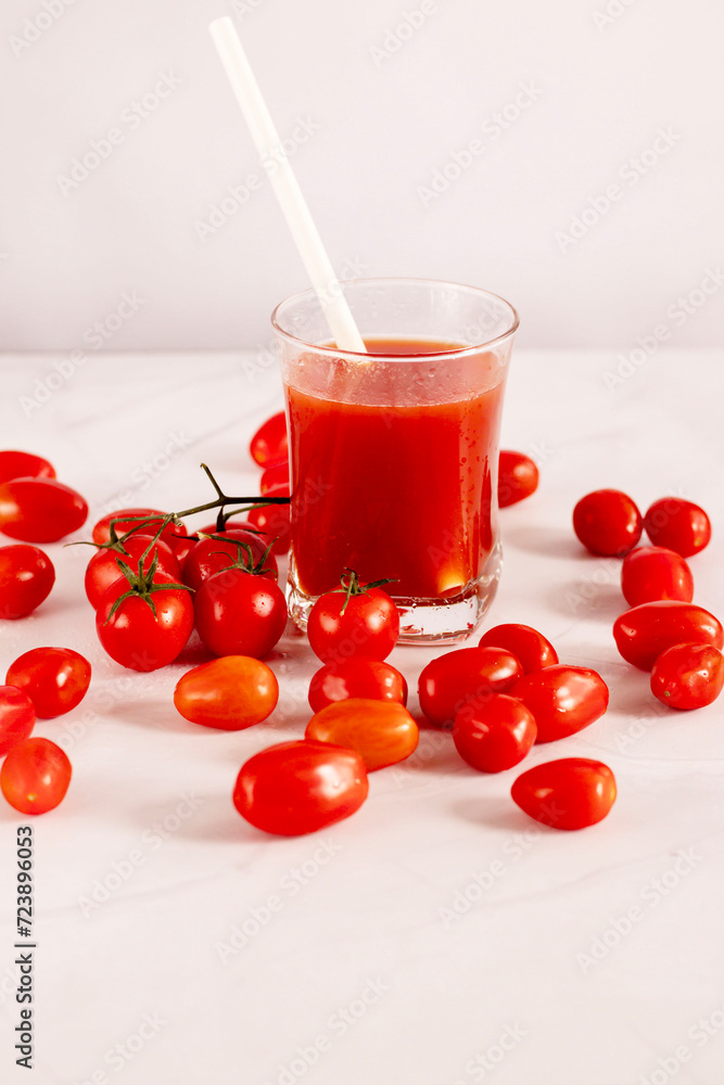 Tomato juice in a glass and fresh tomatoes. on a white background. food
