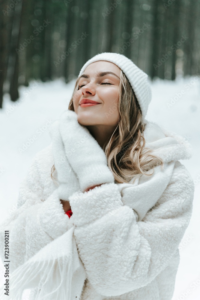 Young woman Enjoying snowy winter forest and warm clothes. Dressed white coat scarf hat and mittens fold palms to face Young woman Enjoying snowy winter forest and warm clothes. Dressed white coat scarf hat and mittens fold palms to face