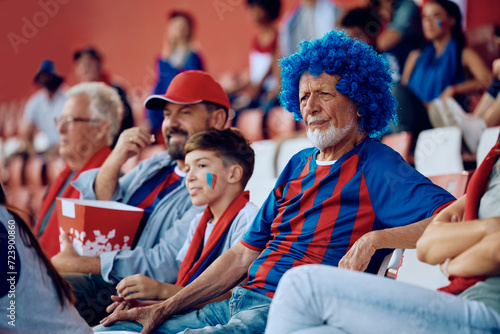 Senior man feeling displeased while watching his favorite sport team loosing match at stadium.
