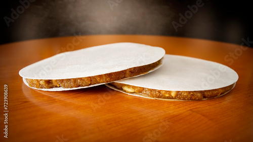 Two Alajú cakes, a Castilian sweet of Arab origin, traditional in the regions of Cuenca and Rincón de Ademuz in Spain, displayed on a wooden table photo